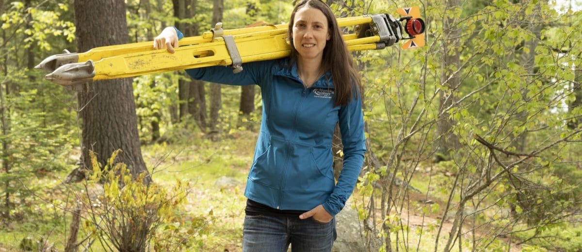 tara hartson posing with surveying equipment