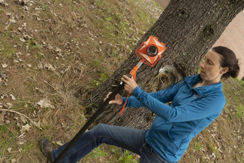 tara hartson using surveying equipment