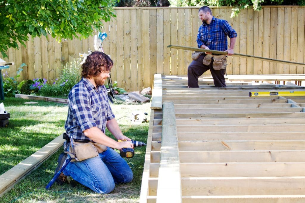 photo of men working on a deck in the summer